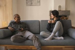Couple sitting on a couch having a warm conversation, representing open communication in counseling