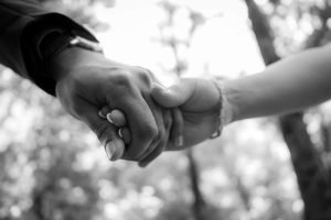 Close-up of a couple holding hands, symbolizing trust and connection in couples therapy