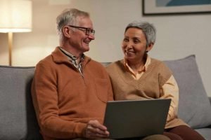 Older couple sitting together with a laptop during a virtual couples therapy session