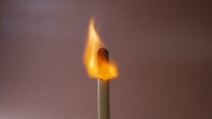Close-up of a burning match symbolizing addiction triggers and warning signs
