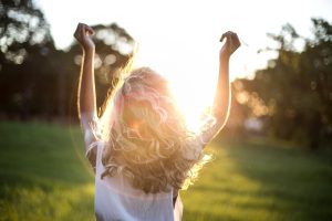 Person standing in sunlight with arms raised, representing emotional release and progress through anxiety therapy.